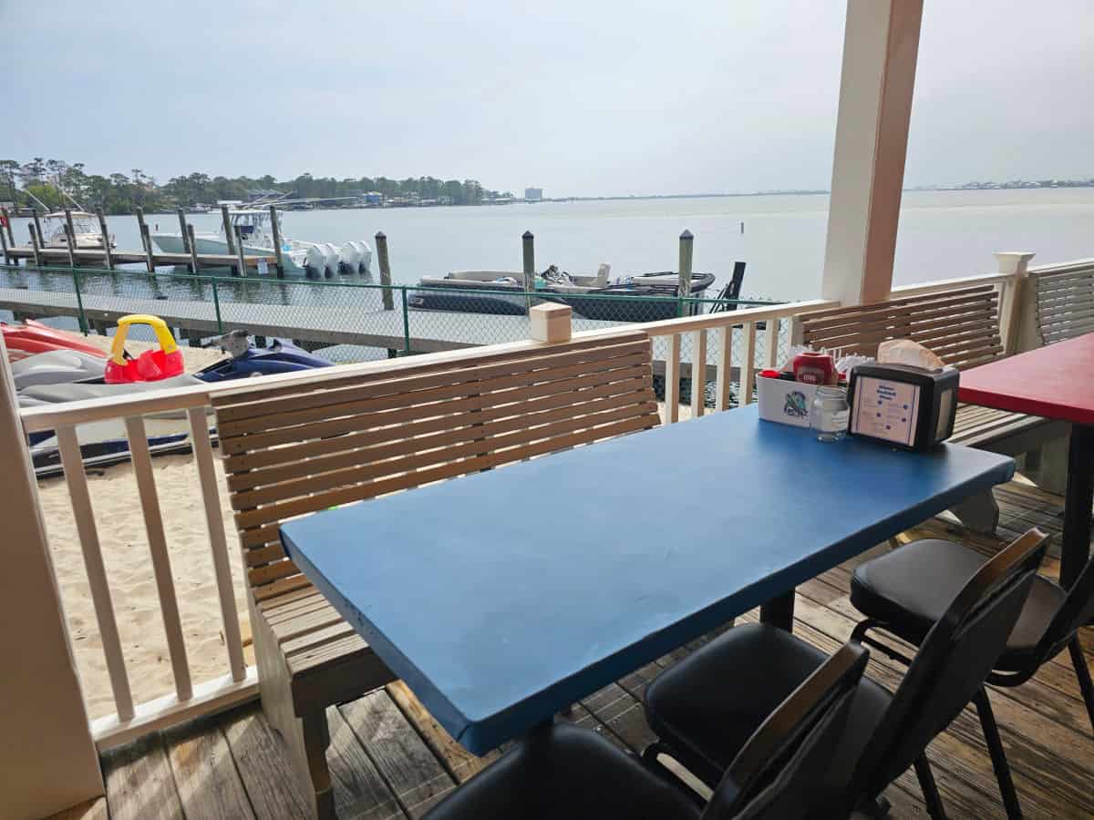 Susnet grille seating with benches, table and chairs over looknig the water with boats at the dock