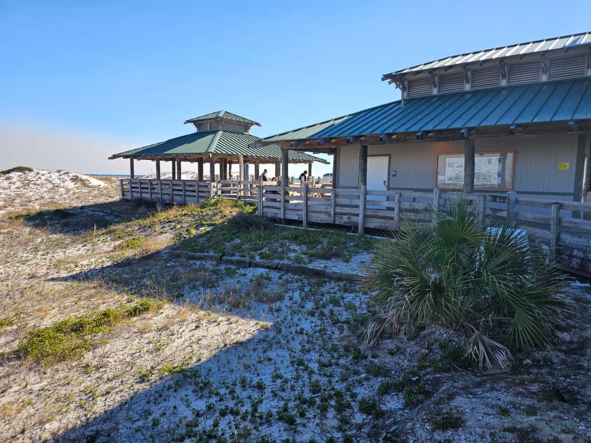 Building with covered area seen over a sand dune