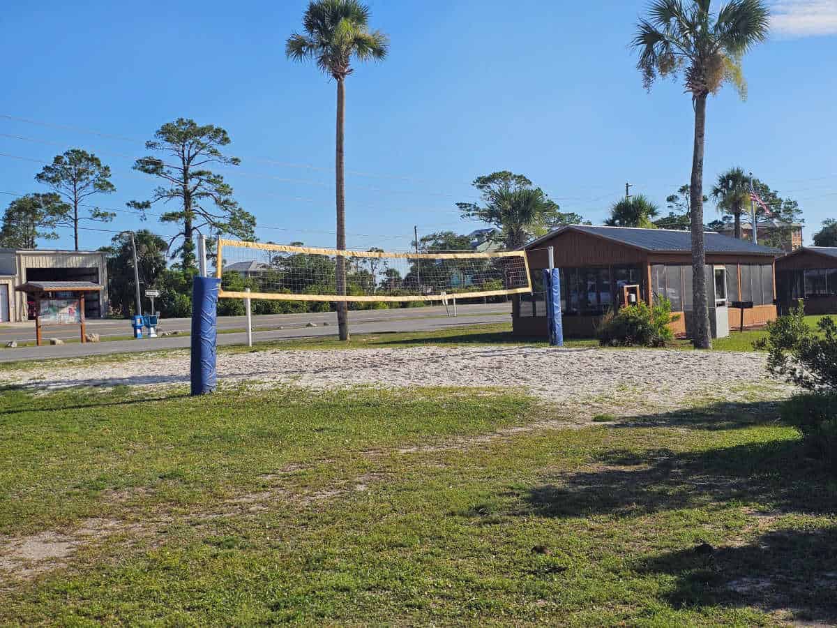 sand volleyball court next to covered picnic area