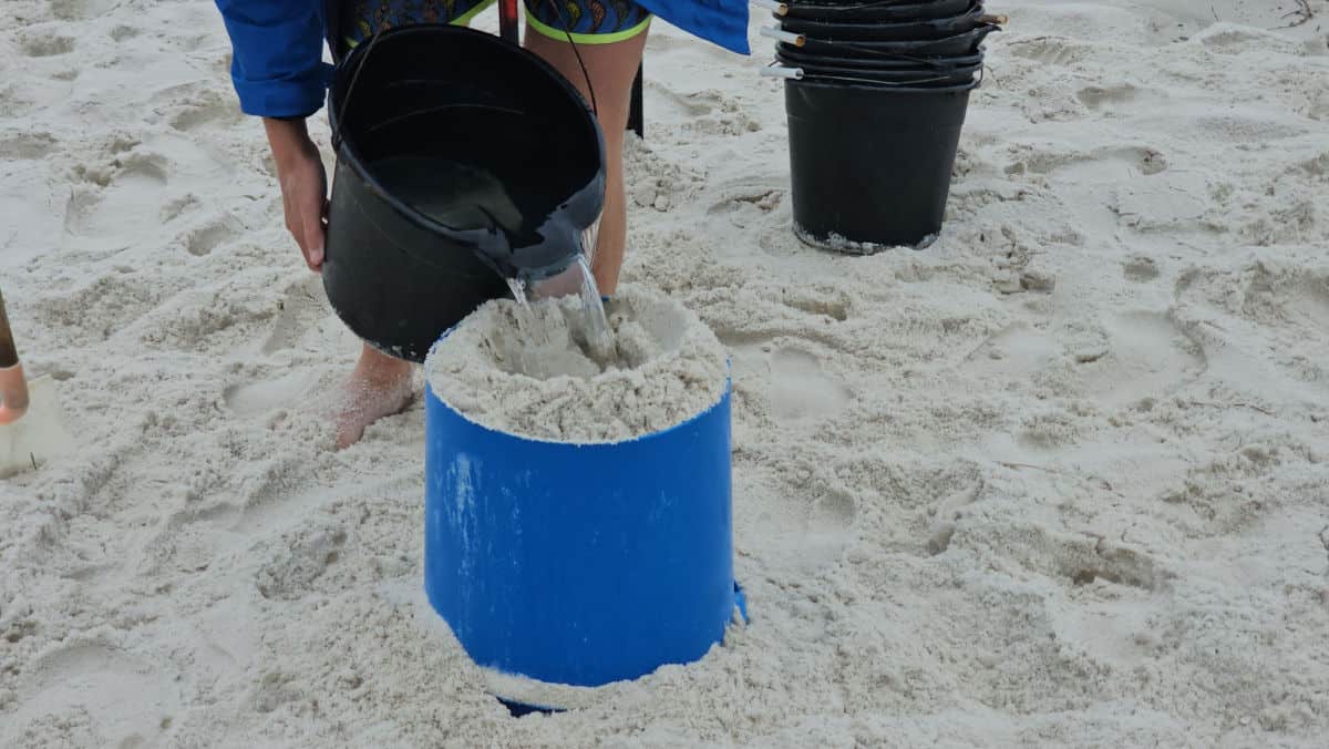 water pouring into sand in a form at sand castle university