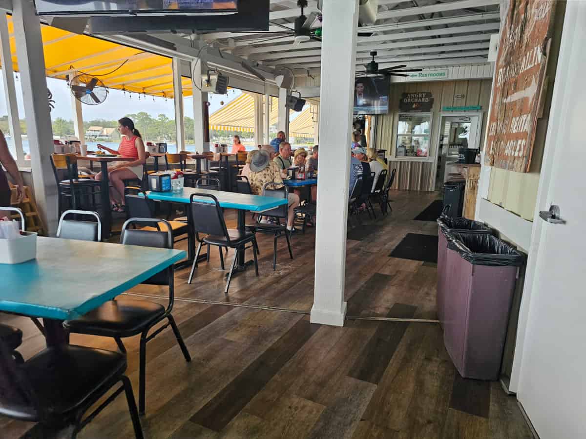 covered seatig with tables and chairs and a yellow awning