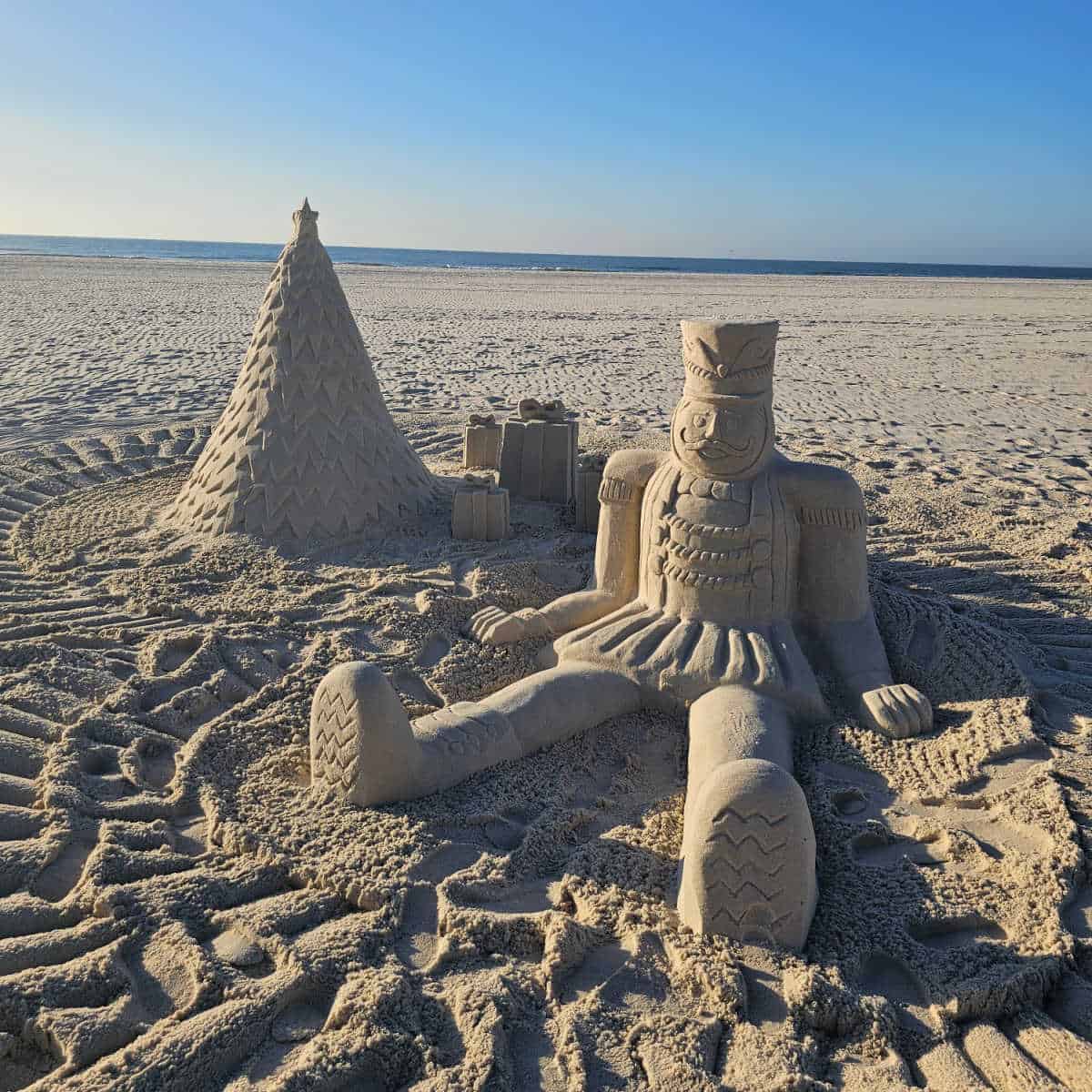 Sand Castle University sand castle of a toy soldier and Christmas Tree on the beach with the Gulf in the background