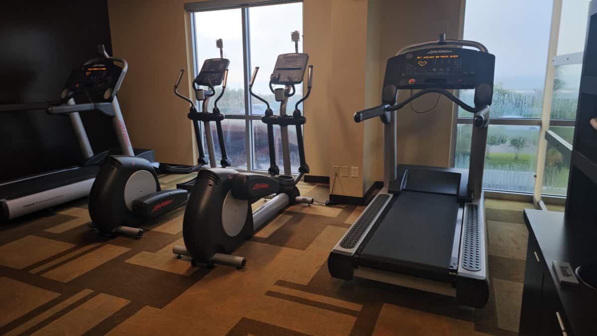 fitness center looking out to the beach with treadmills and elipticals
