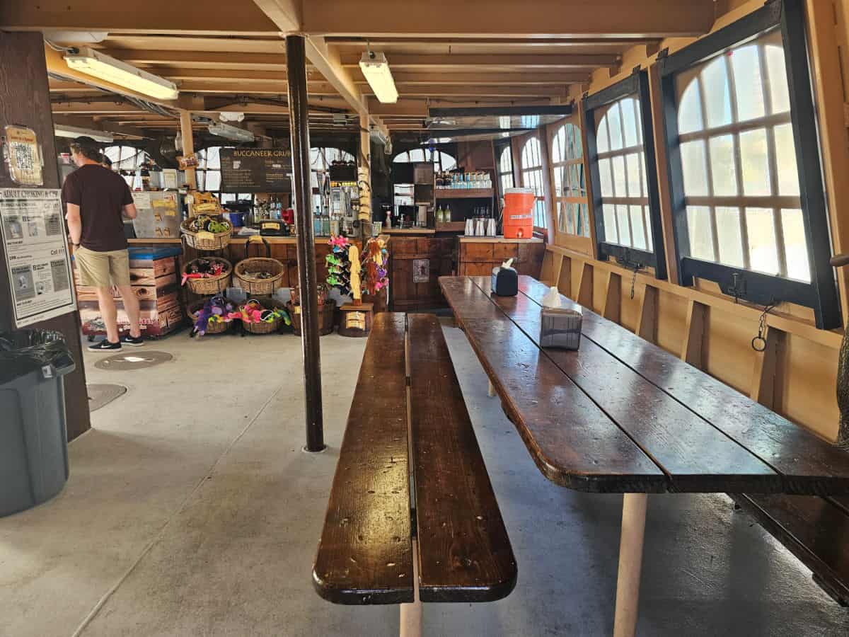 indoor seating with a long table leading to the galley with drins and souvenirs for sale