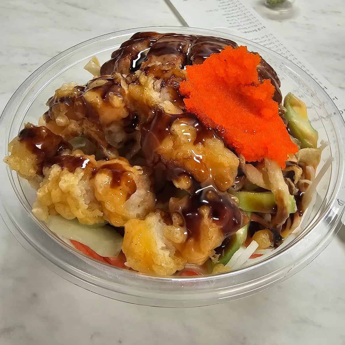 Bowl with fried chicken, sauce, and vegetables