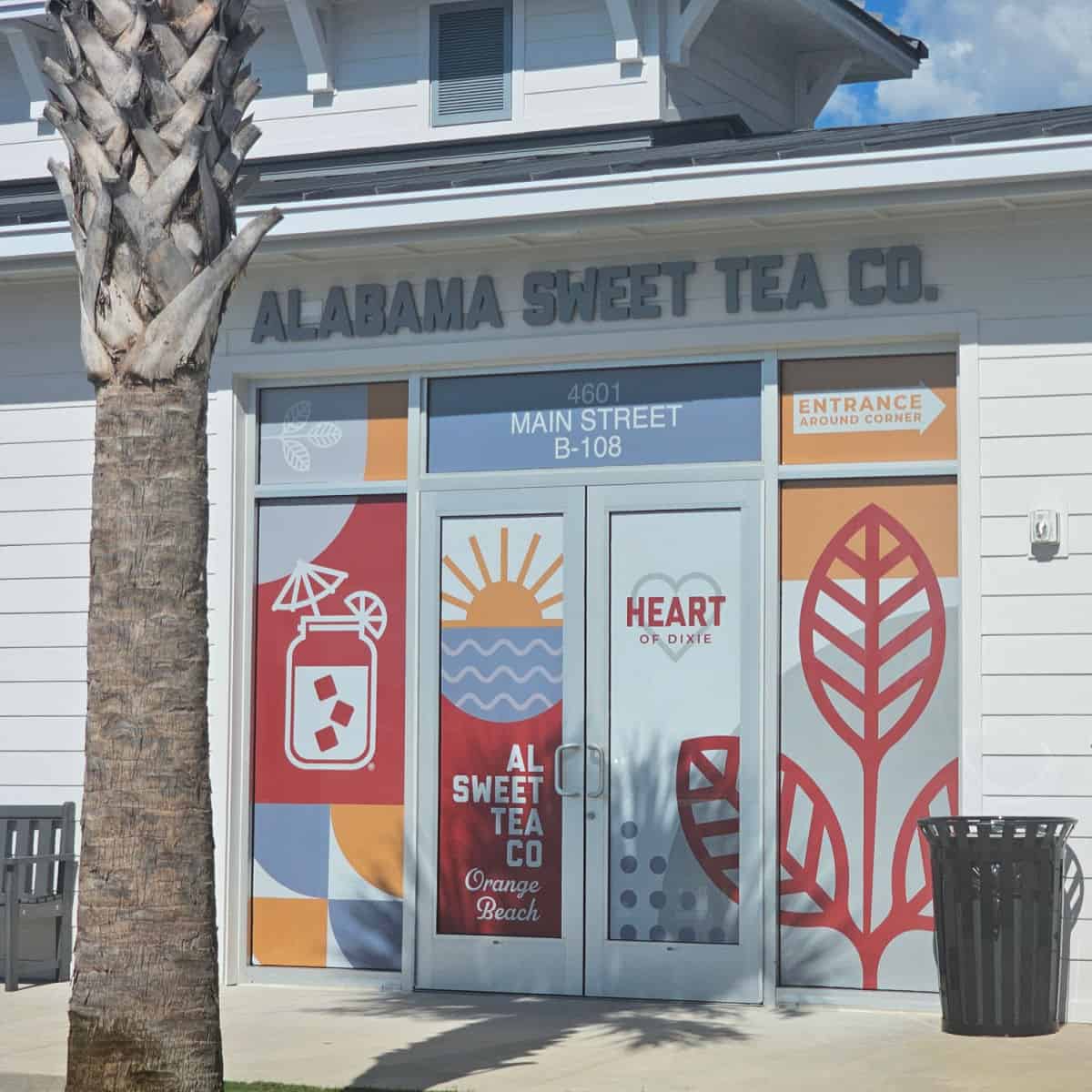 Alabama Sweet Tea Co. sign above a door with graphics and al sweet tea co orange beach