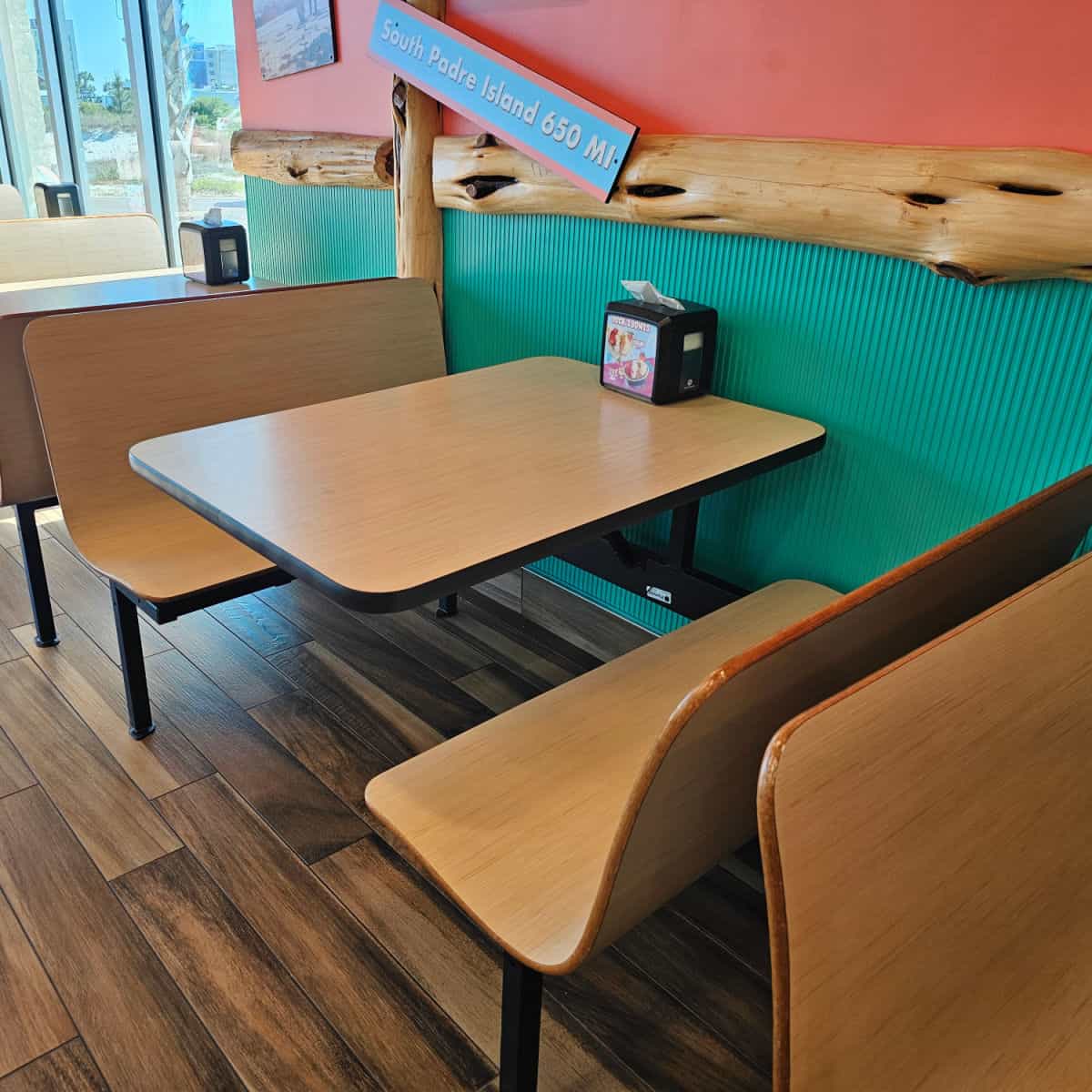 Indoor seating with booths with tables, and napkin dispenser
