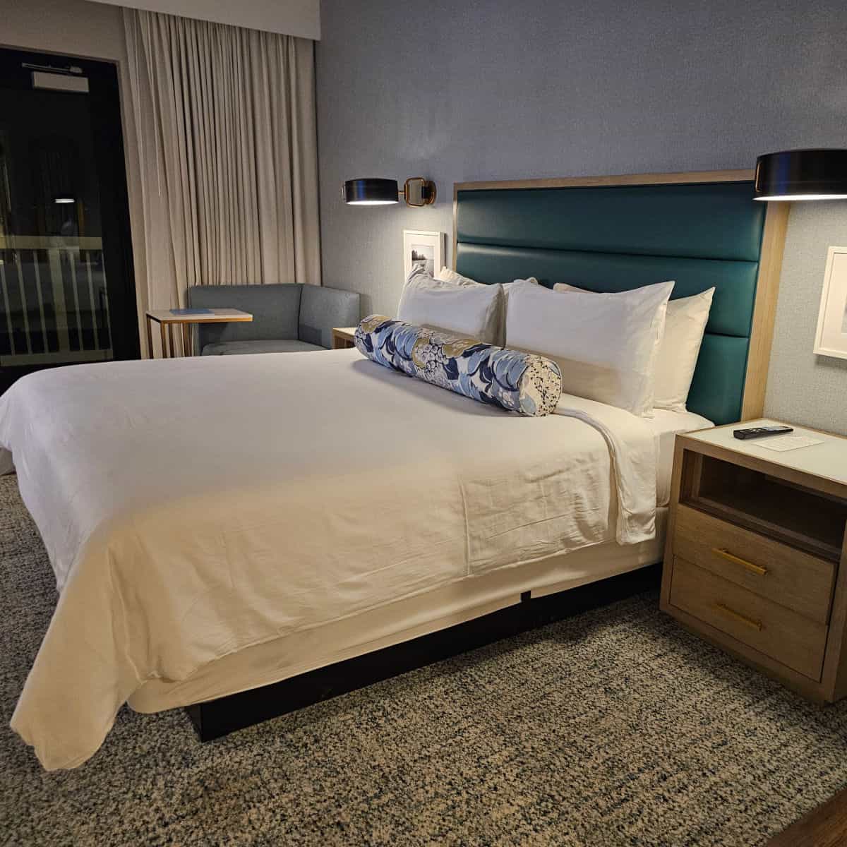 king bed with a floral bolster across the top by the pillows