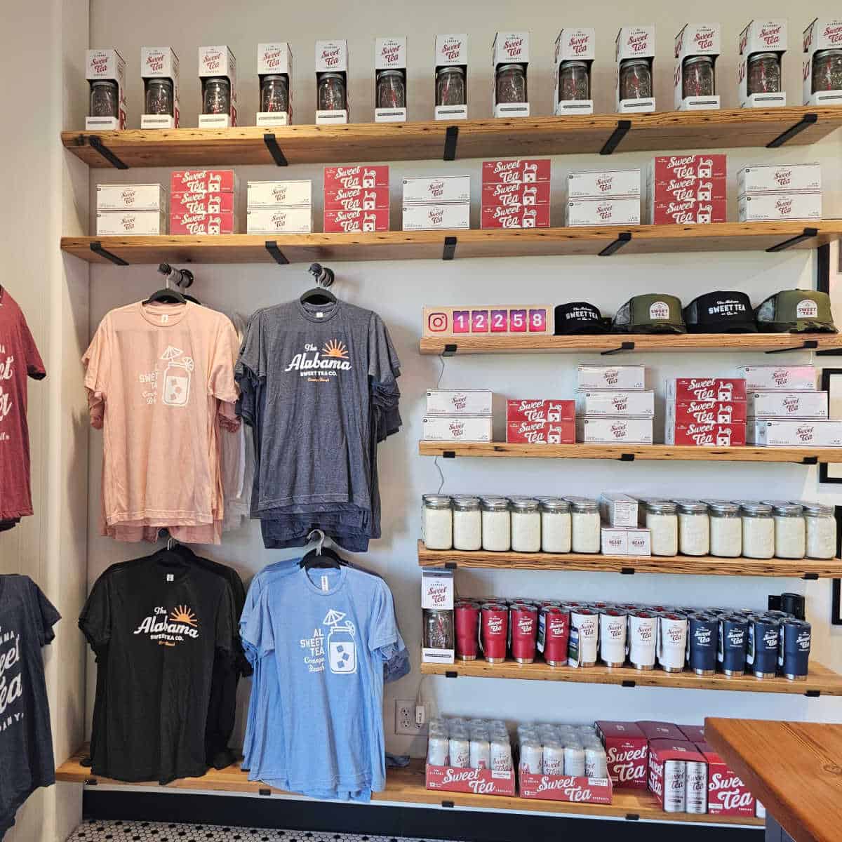 Wall of Alabama Sweet Tea Co merchandise including cups, t-shirts, and hats