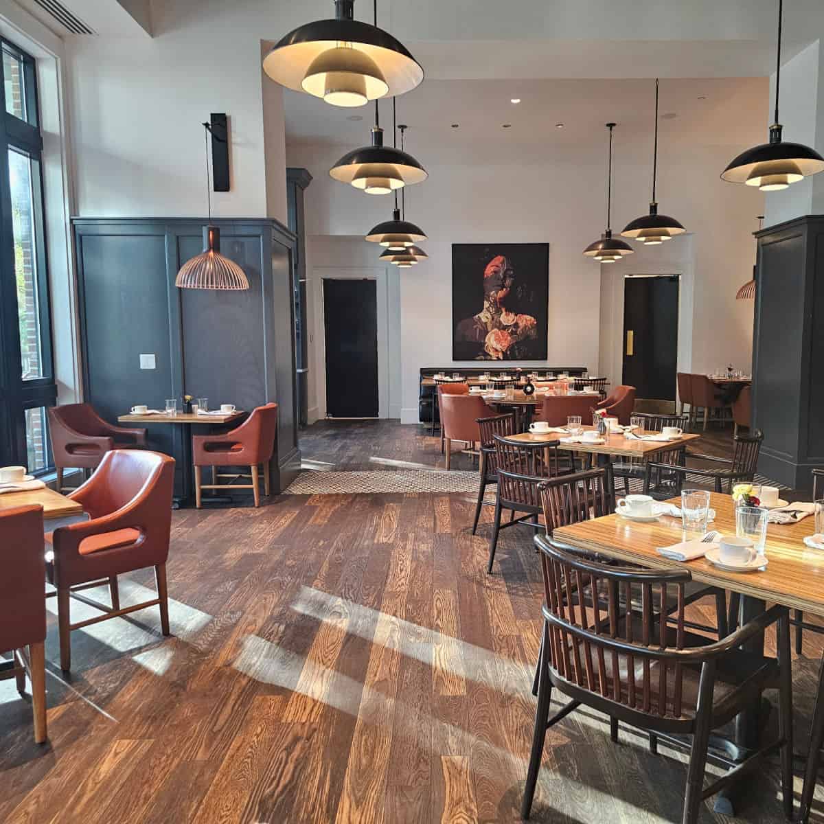 oivde restaurant seating with a painting on the wall, tables and chairs