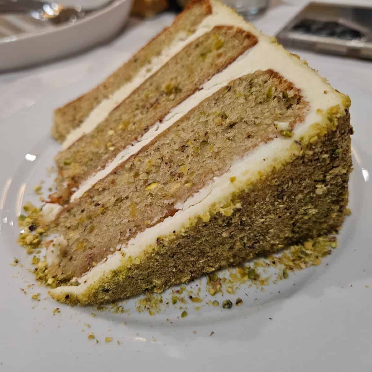 Pisatchio Cake with three layers on a white plate at Fresco in Bon Secour