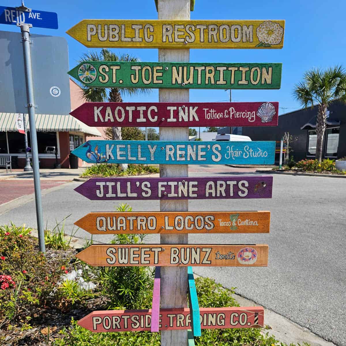 multicolored street signs pointing towards shops and restaurants on Reid Avenue in port st joe florida