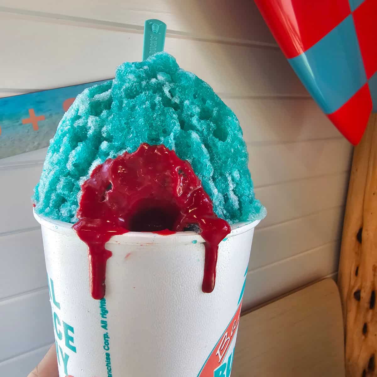 Shark attack sno with red liquid coming out of a blue snowcone