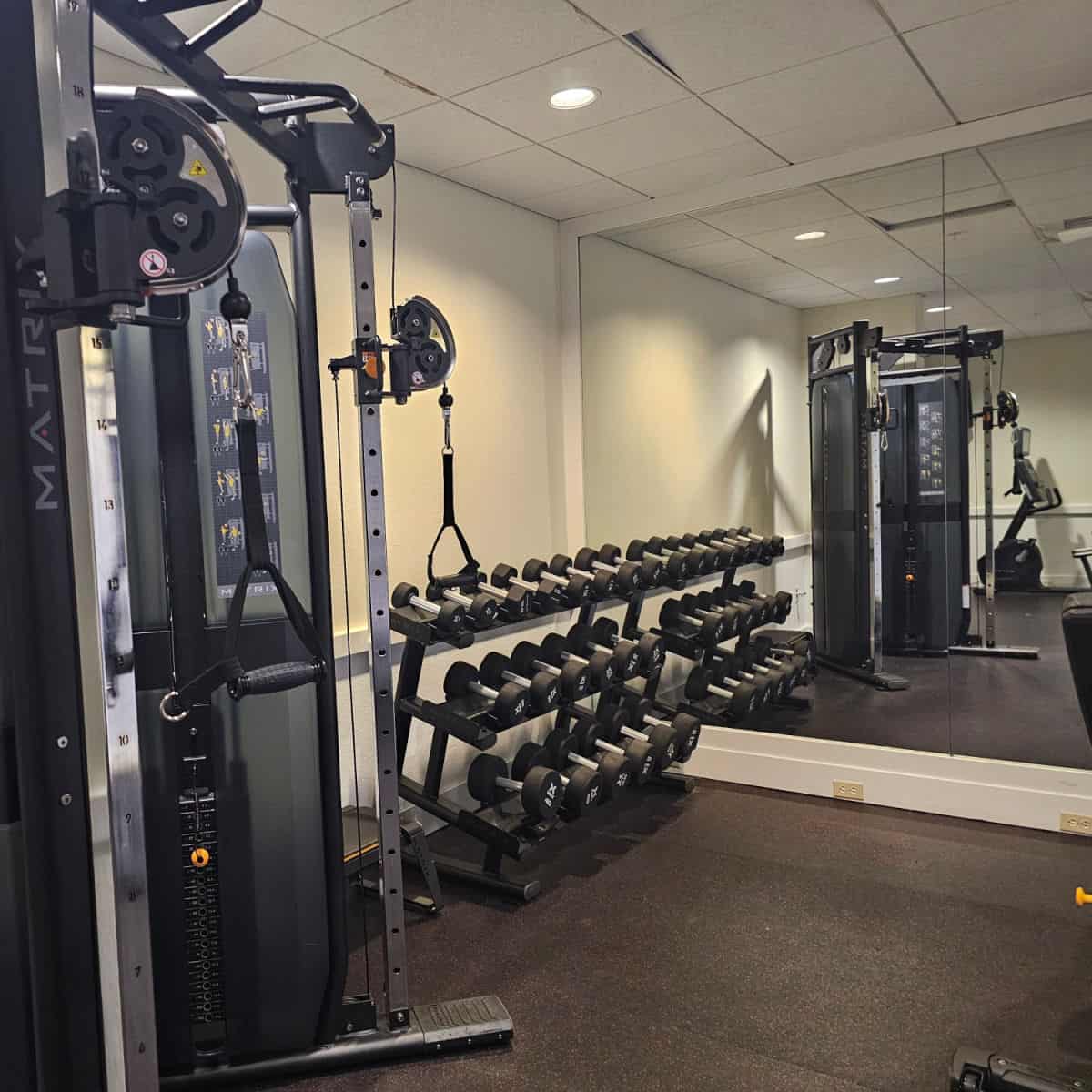 Fitness center with mirrow, free weights, and a weight machine at the Courtyard Sandestin
