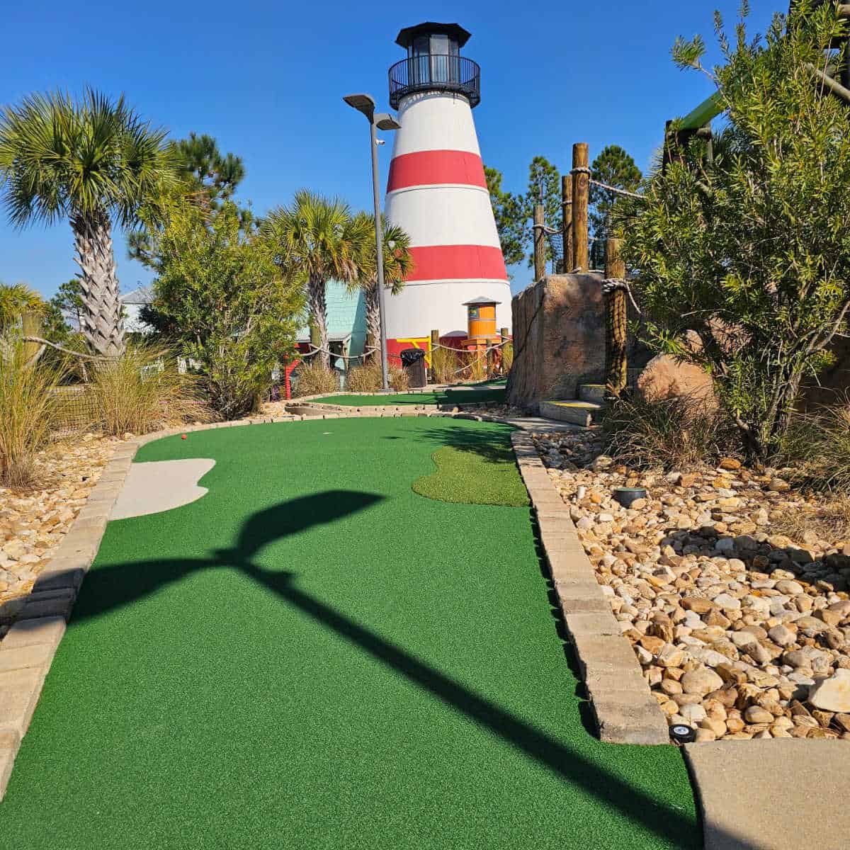 mini golf hole going up a small hill towards the lighthouse.