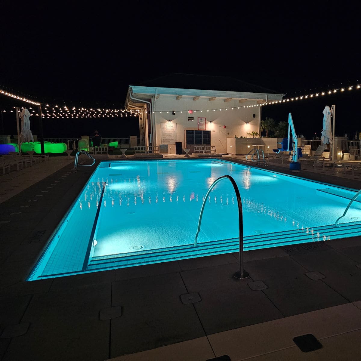 rooftop pool at night lit up with string lights at the Hotel Effie