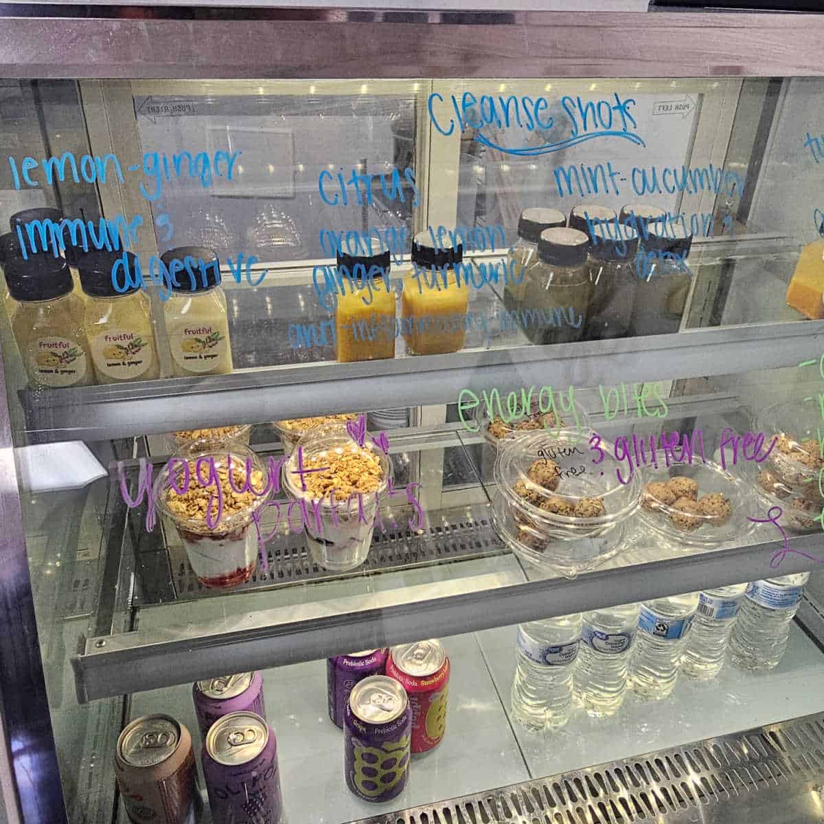 refrigerator case with juices, yogurt parfairs, energy bites, and water bottles