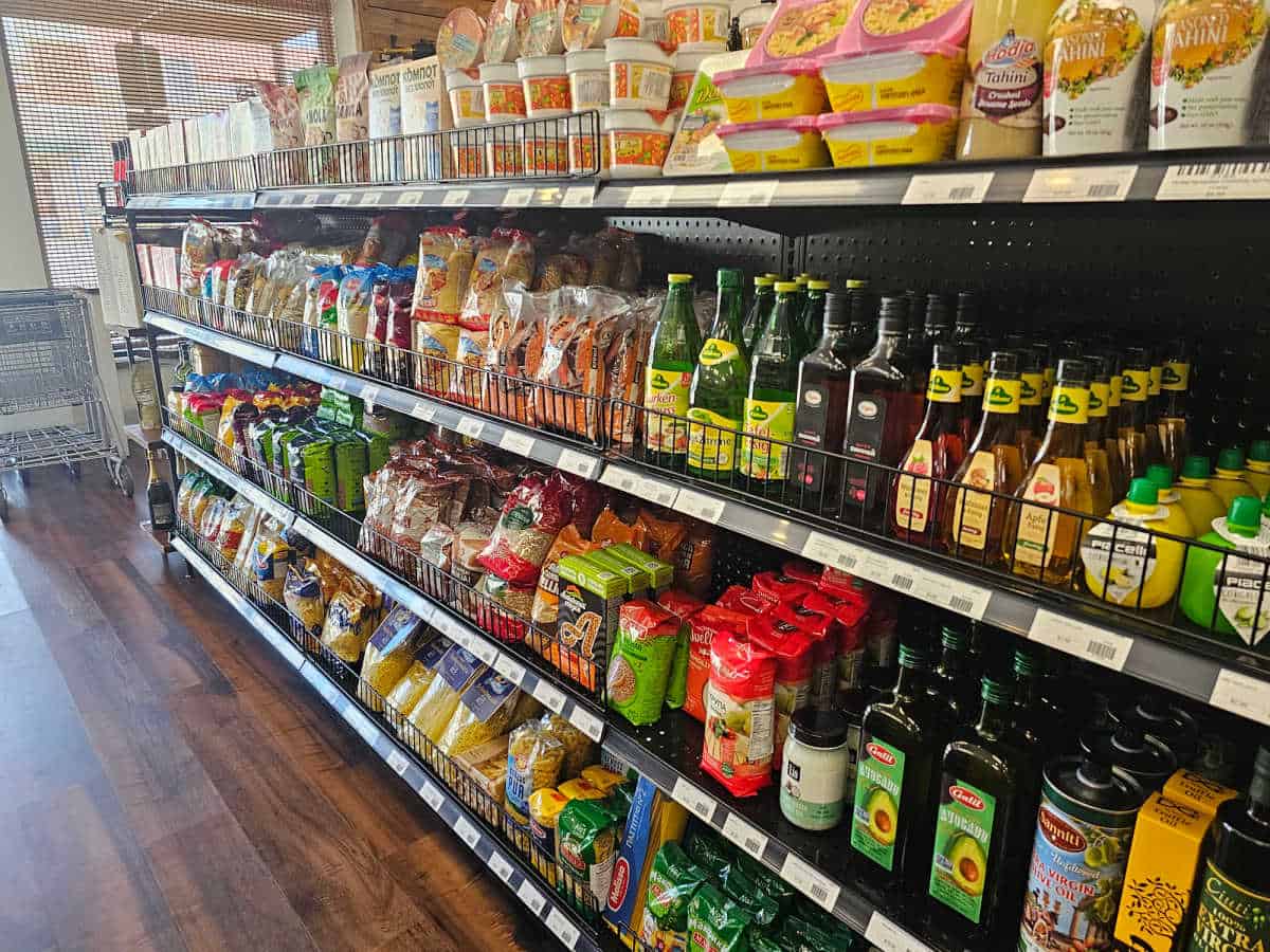 grocery shelves with condiments, olive oil, tahini