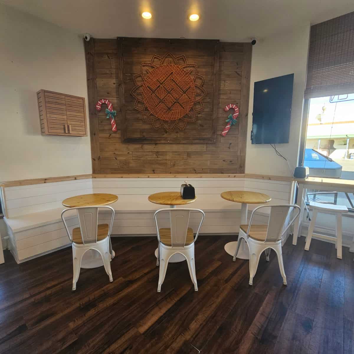 indoor seating with small tables next to a wrap around white bench