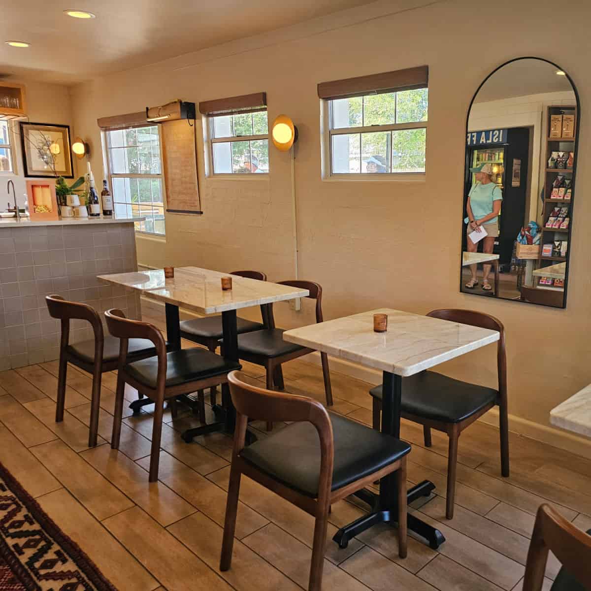 inside isla wine with tables and chairs, mirror and wine bar