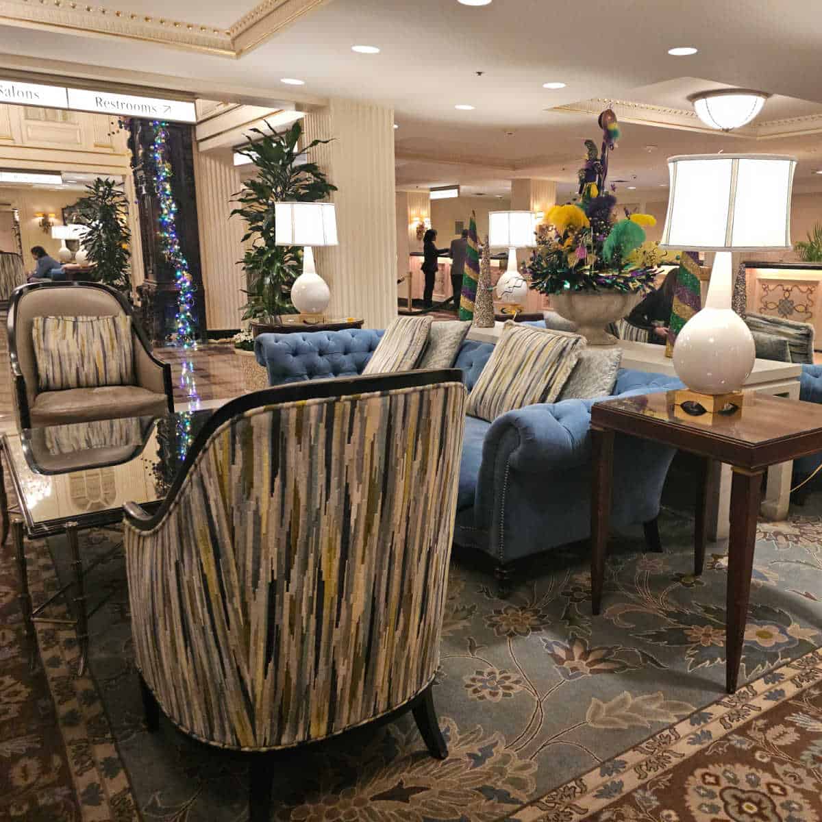 Hotel Montleone lobby with chairs, blue couch, mardi gras floral displays