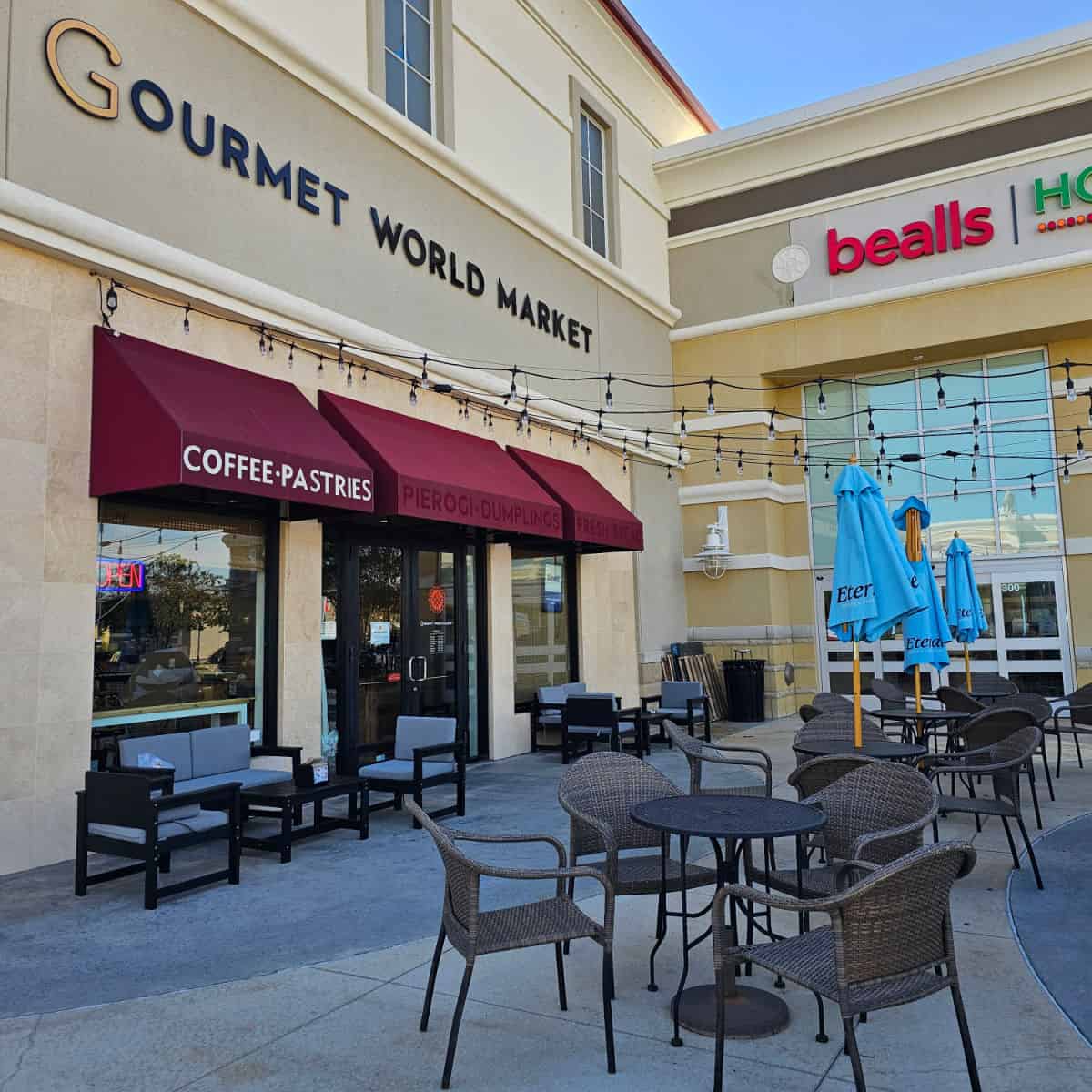 Gourmet World Market Sign over glass doors and outdoor seating