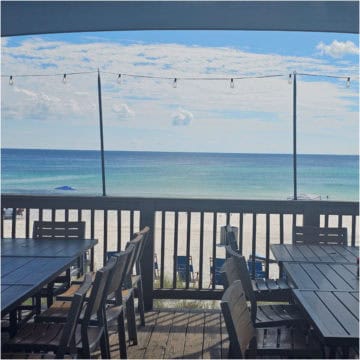Beachfront dining with ocean view and outdoor seating.