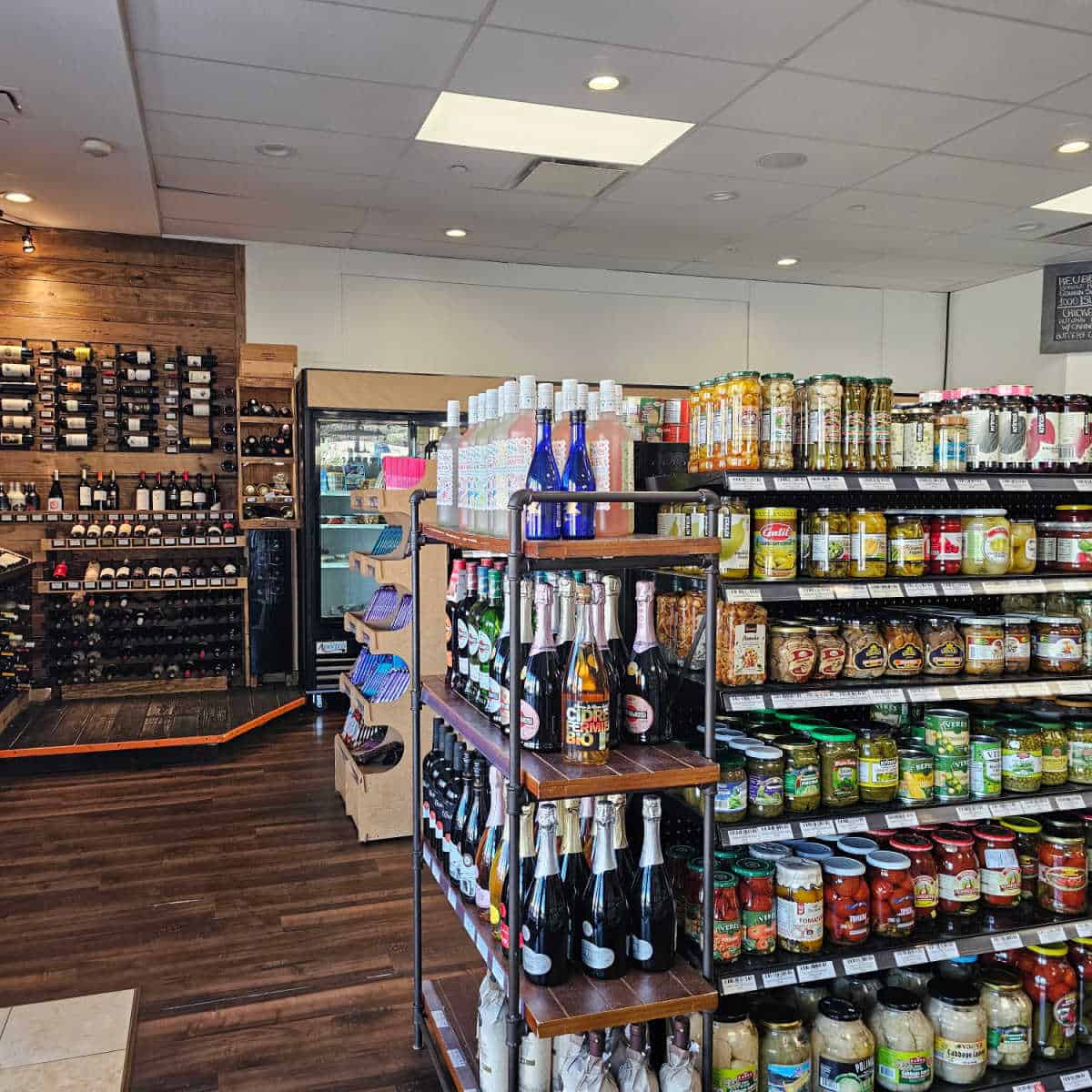Gourmet World Market grocery shelves with condiments, wine, and snacks