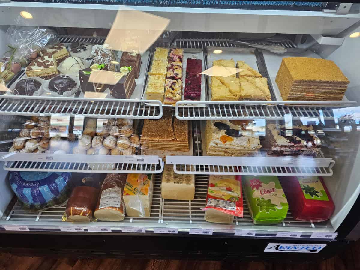 desserts and cheese by the pound in a refrigerator case