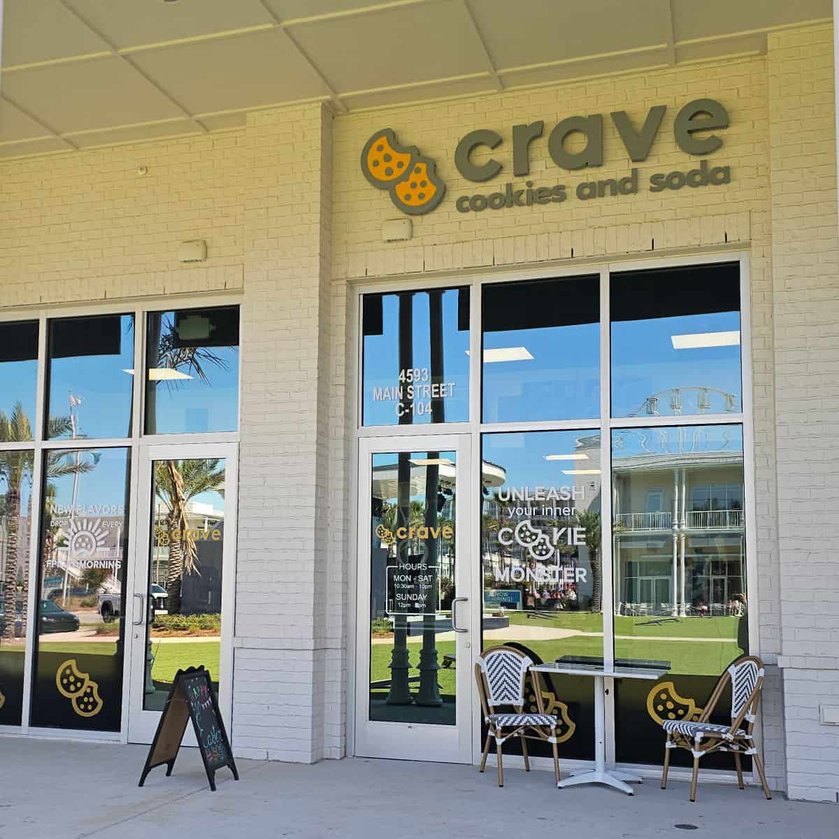 Crave Cookies and Soda exterior with glass windows and two chairs outside
