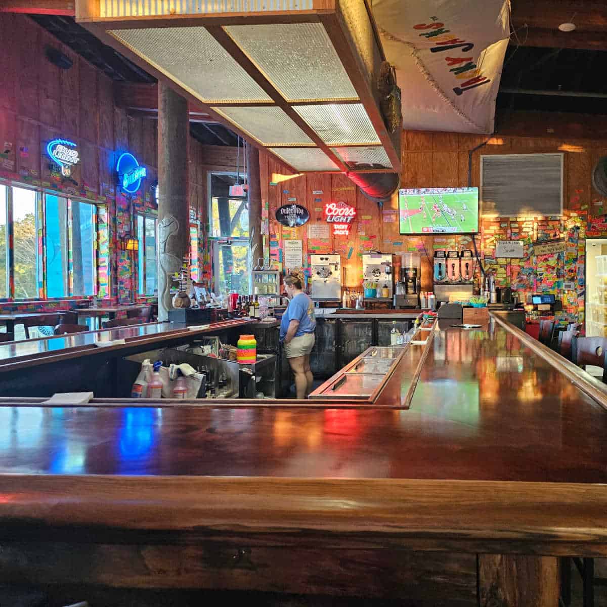 Tacky Jacks bar with a flatscreen on the wall, neon lights, Tacky jacks sail on the ceiling, colorful tape on the wall