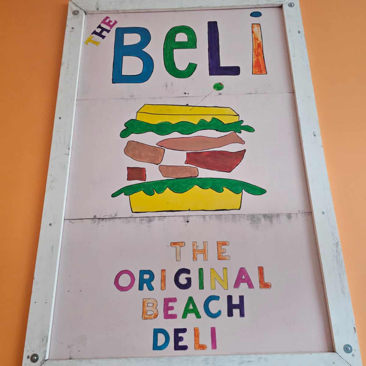 The Beli The Original Beach Deli sign with a colorful sandwich art