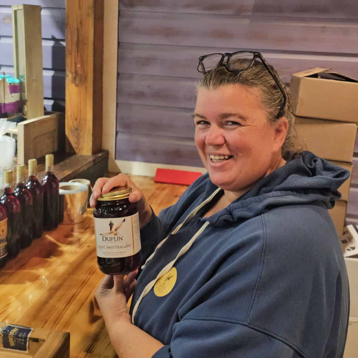 Tammilee holding a bottle of Duplin wine in a jar