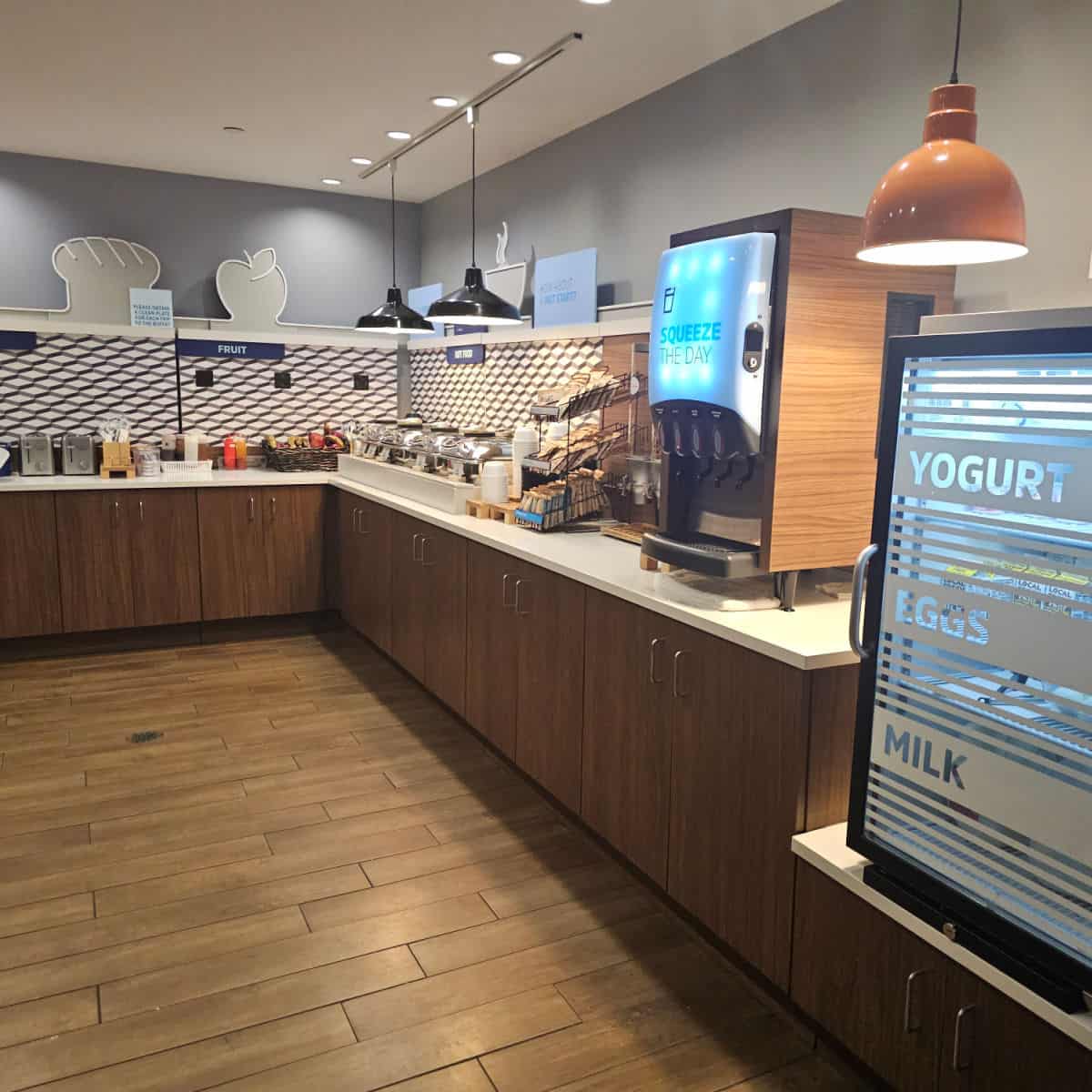 breakfast area with yogurt, eggs, and milk in a fridge, counter with different breakfast options
