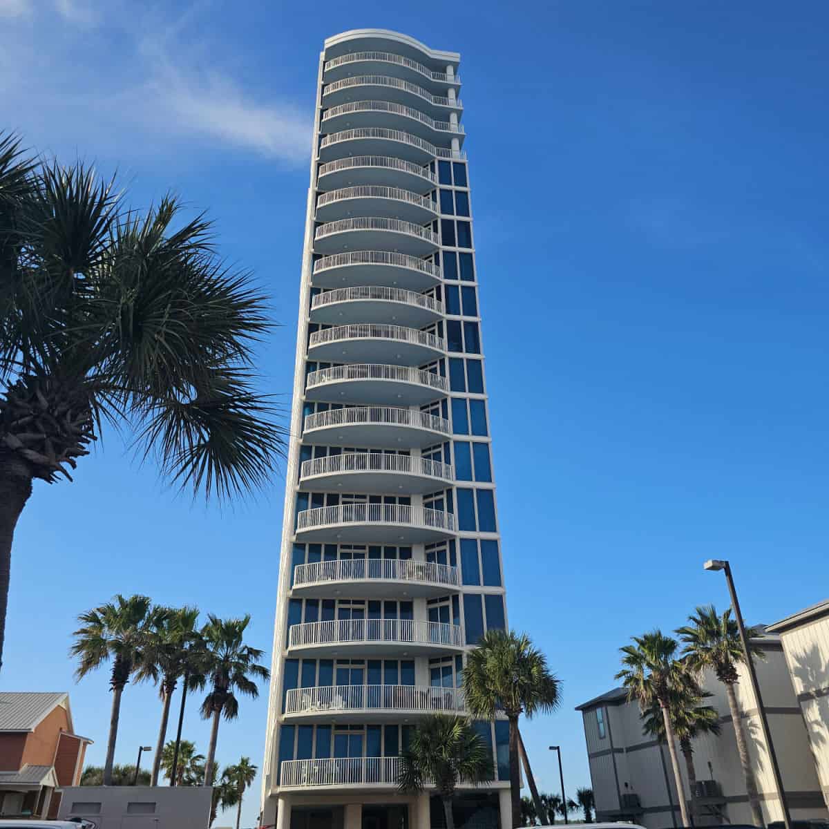 Lagoon Tower condo exterior with balconies on every floor palm trees in the parking lot