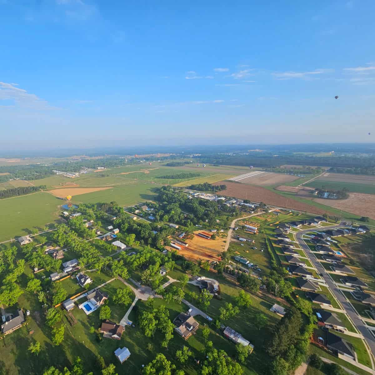 Looking over Foley from the sky with hot air balloons floating
