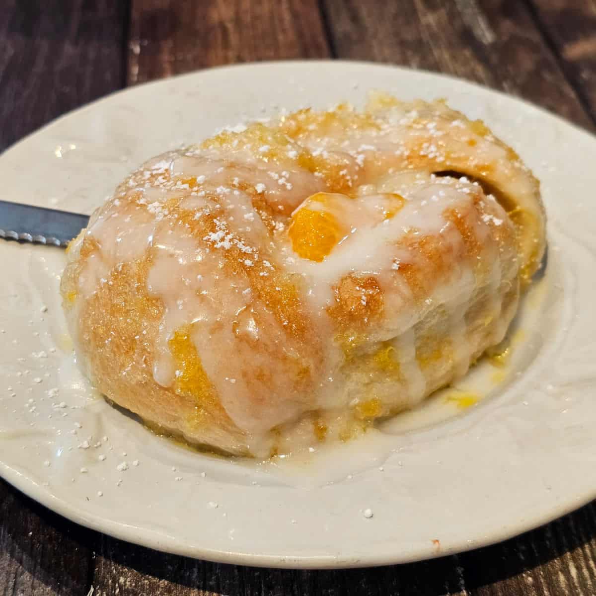 orange cinnamon roll on a white plate at Over Easy Cafe