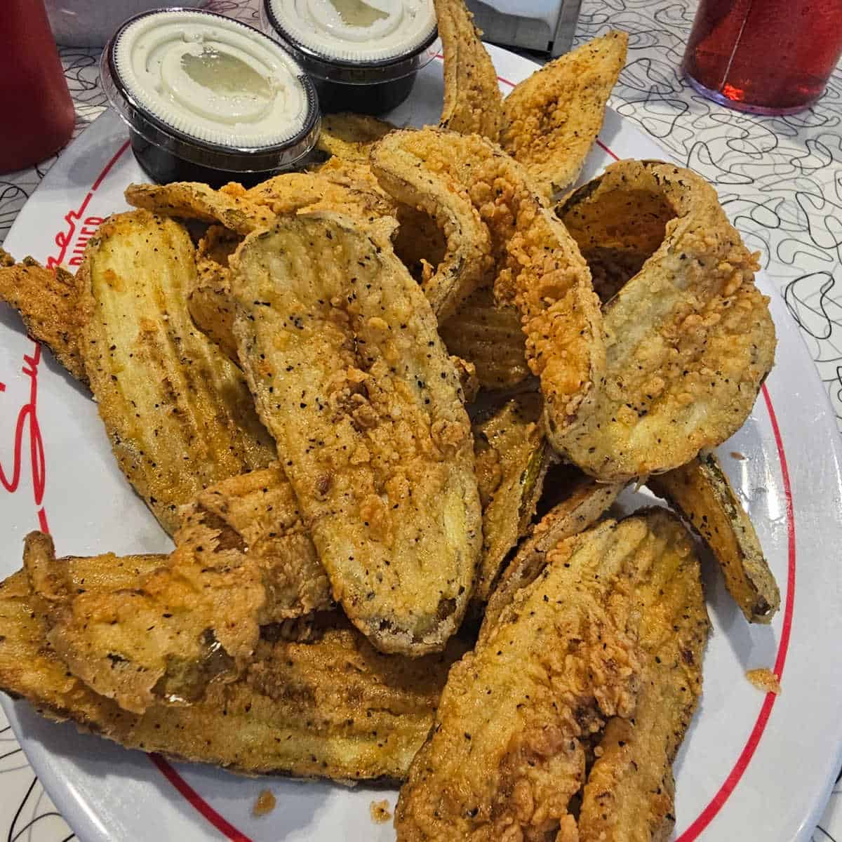 fried pickles on a white plate with sunliner diner printed on it.
