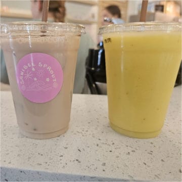 sanibel sprout sticker on an iced chai next to a mango morning smoothie in a plastic cup