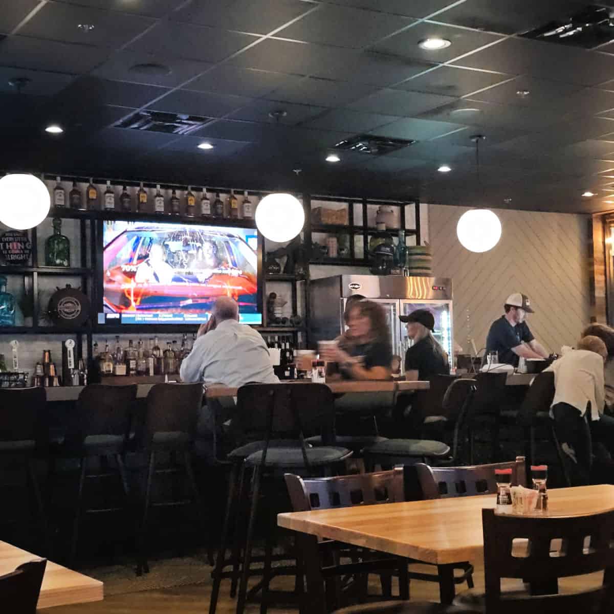 Old Salt Tavern bar area with TV on the wall surrounded by shelves of bottles