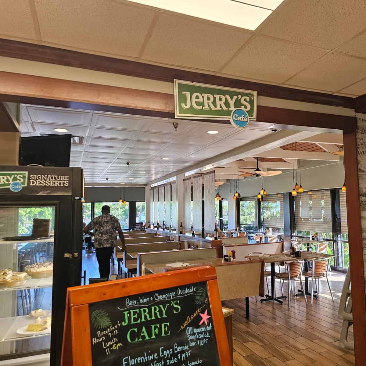 Jerry's Cafe sign over the entrance to the restaurant with booths and tables and chairs, dessert case near the entrance