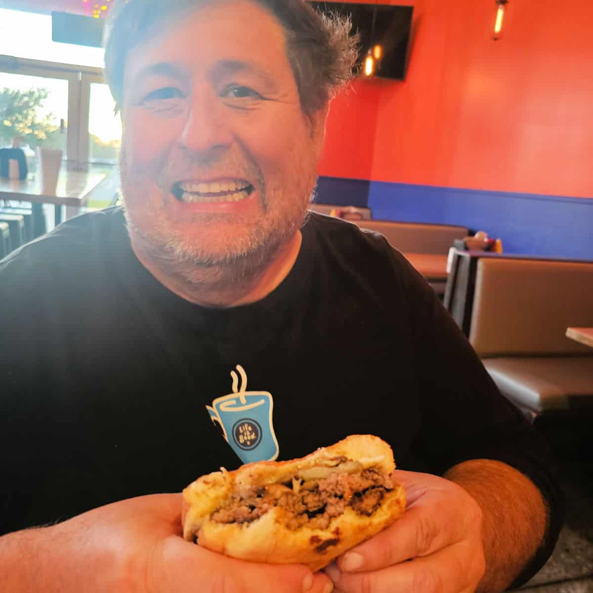 john smiling holding a burger