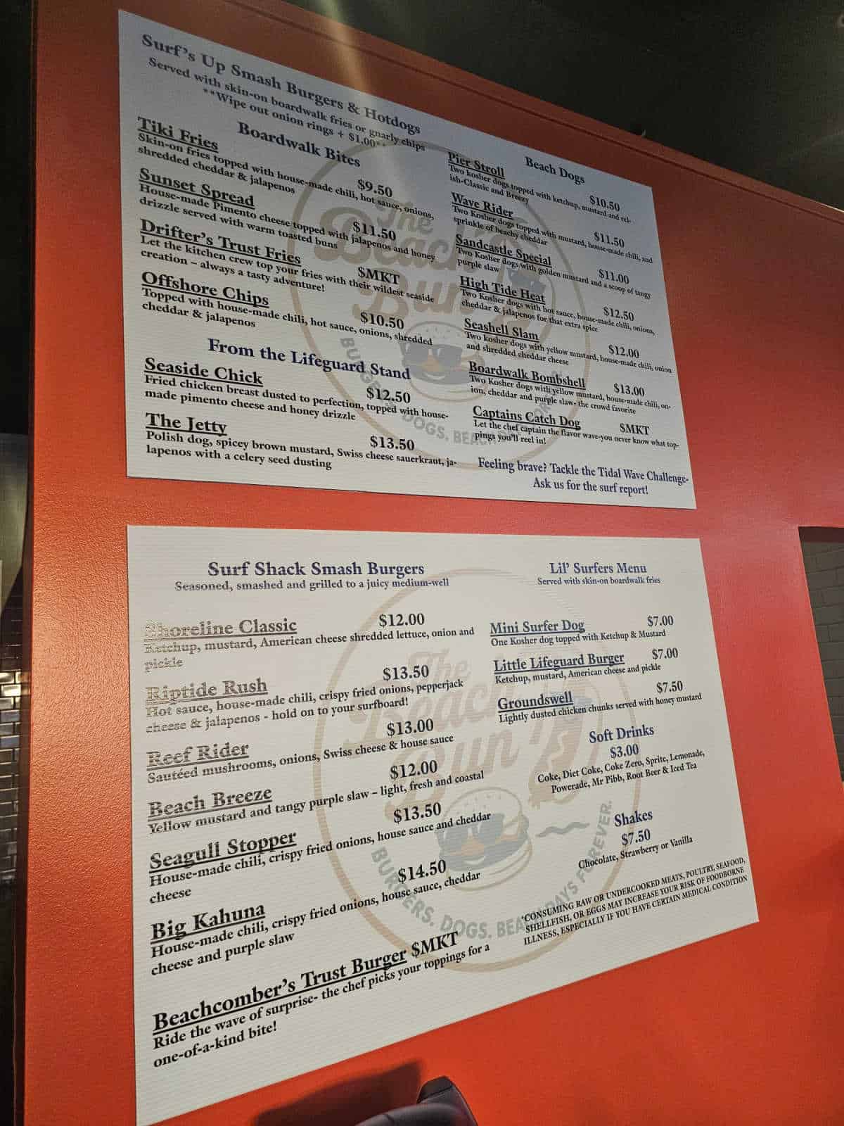 The beach bun menu on white boards against a red wall