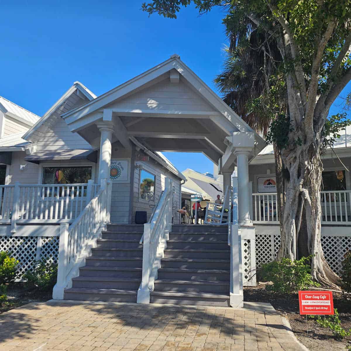 white building with stairs leading up to stores and restaurants, over easy cafe sign