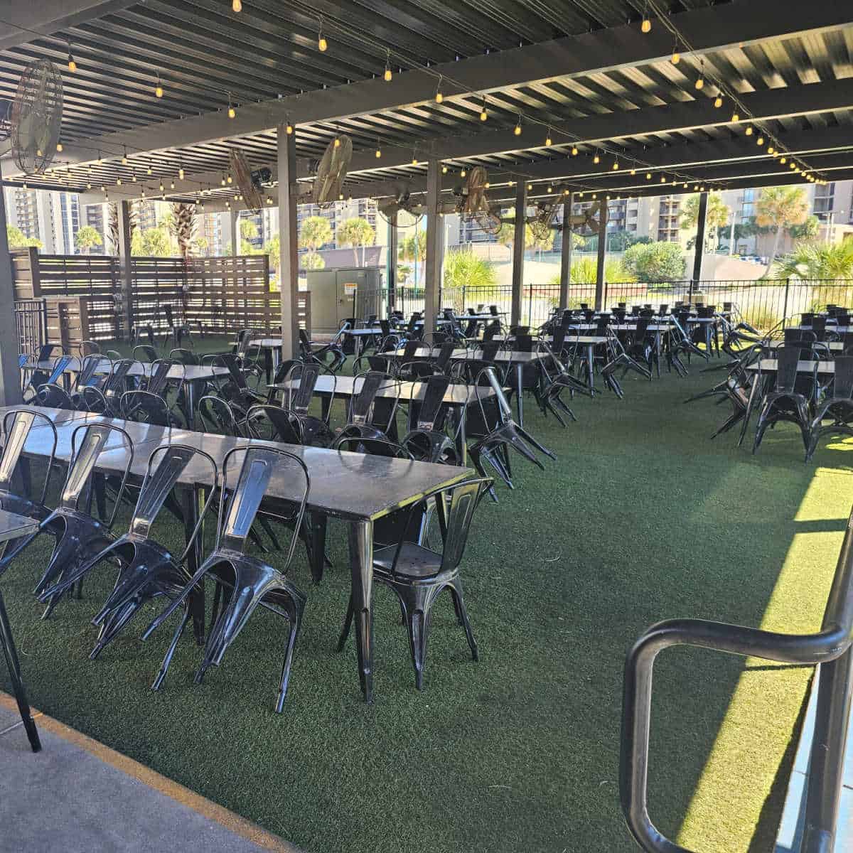 outdoor covered seating with long tablesand chairs learning against the tables