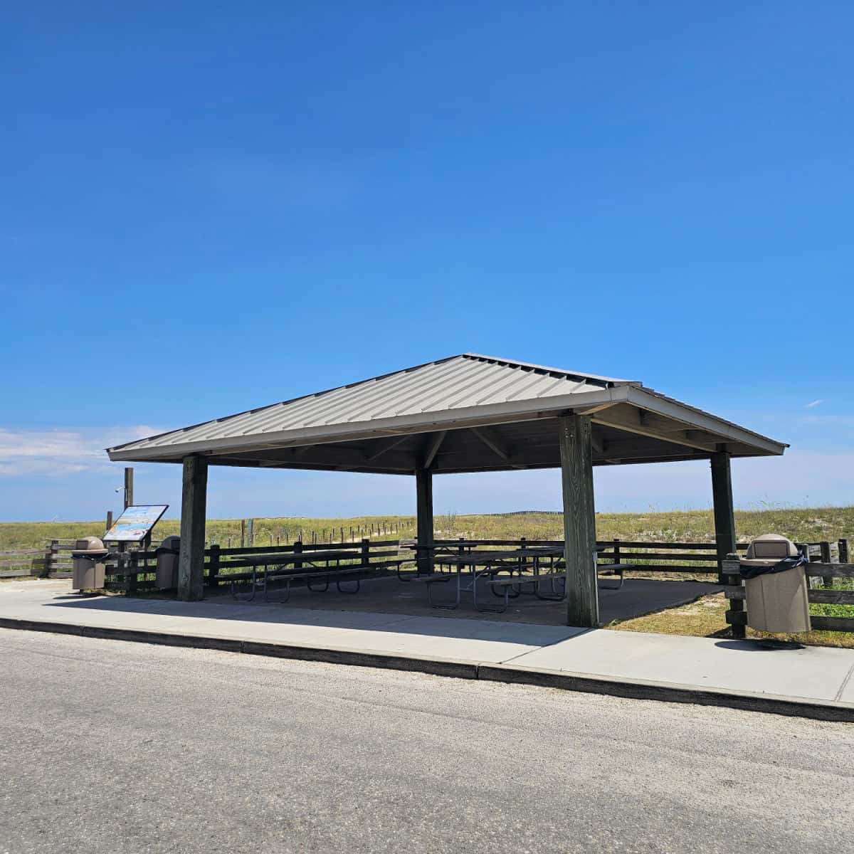 covered picnic shelter with outdoor shower next to it