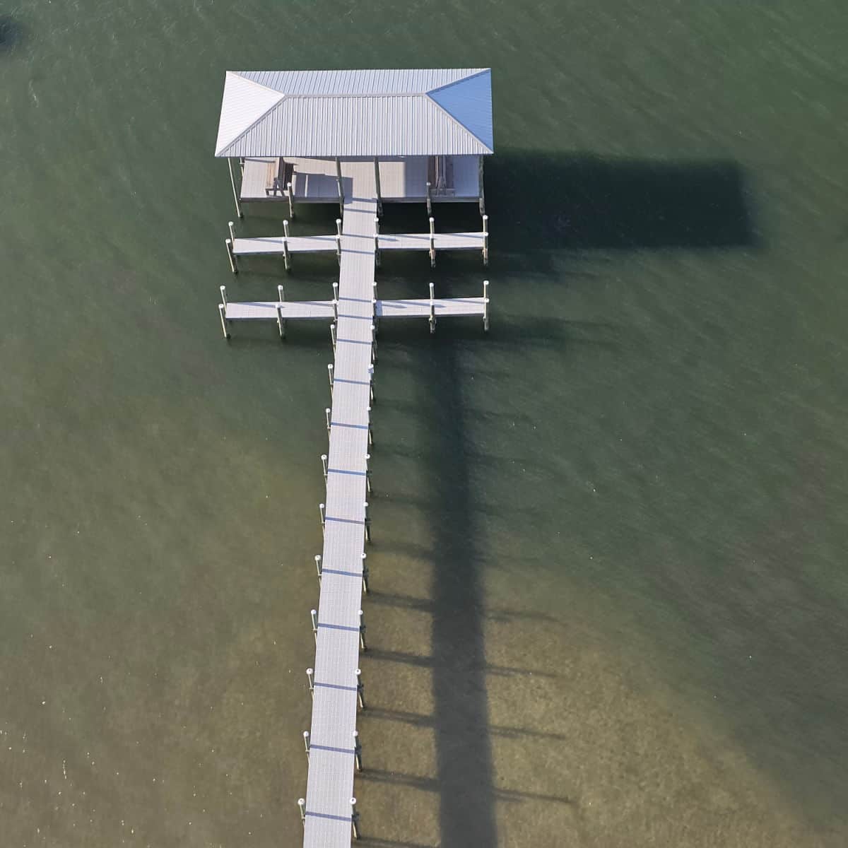 looking down on a covered fishing dock with boat slips