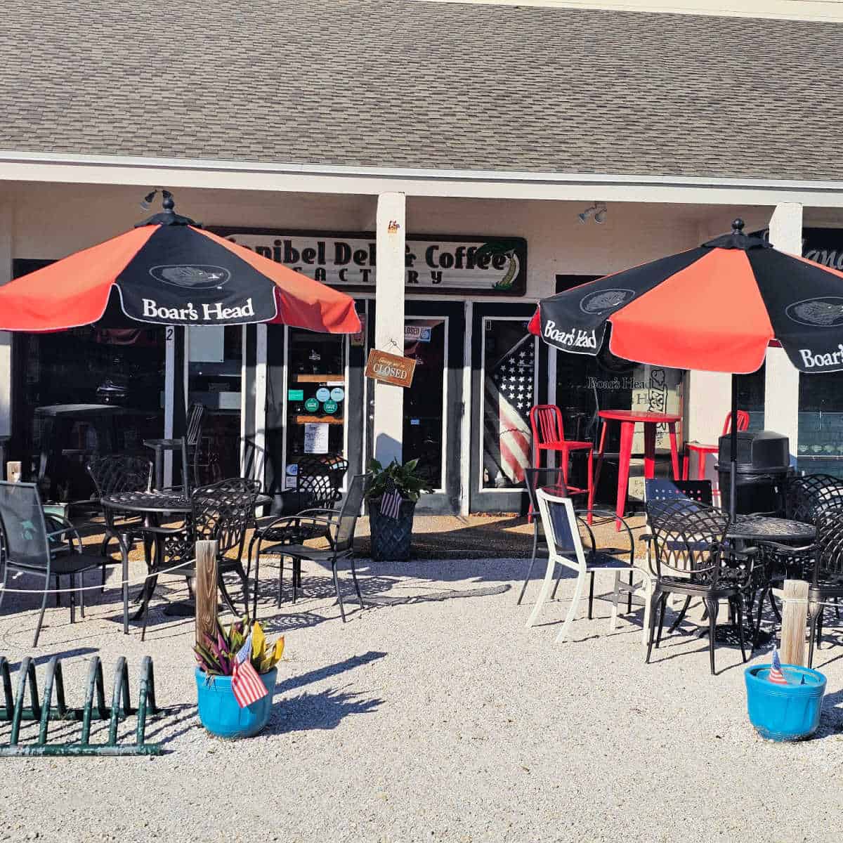 Sanibel Deli & Coffee exterior with tables and chairs with red and black umbrellas over them