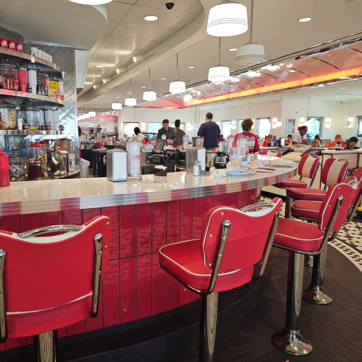 retro dining counter with red padded seats, restaurant filling the rest of the frame