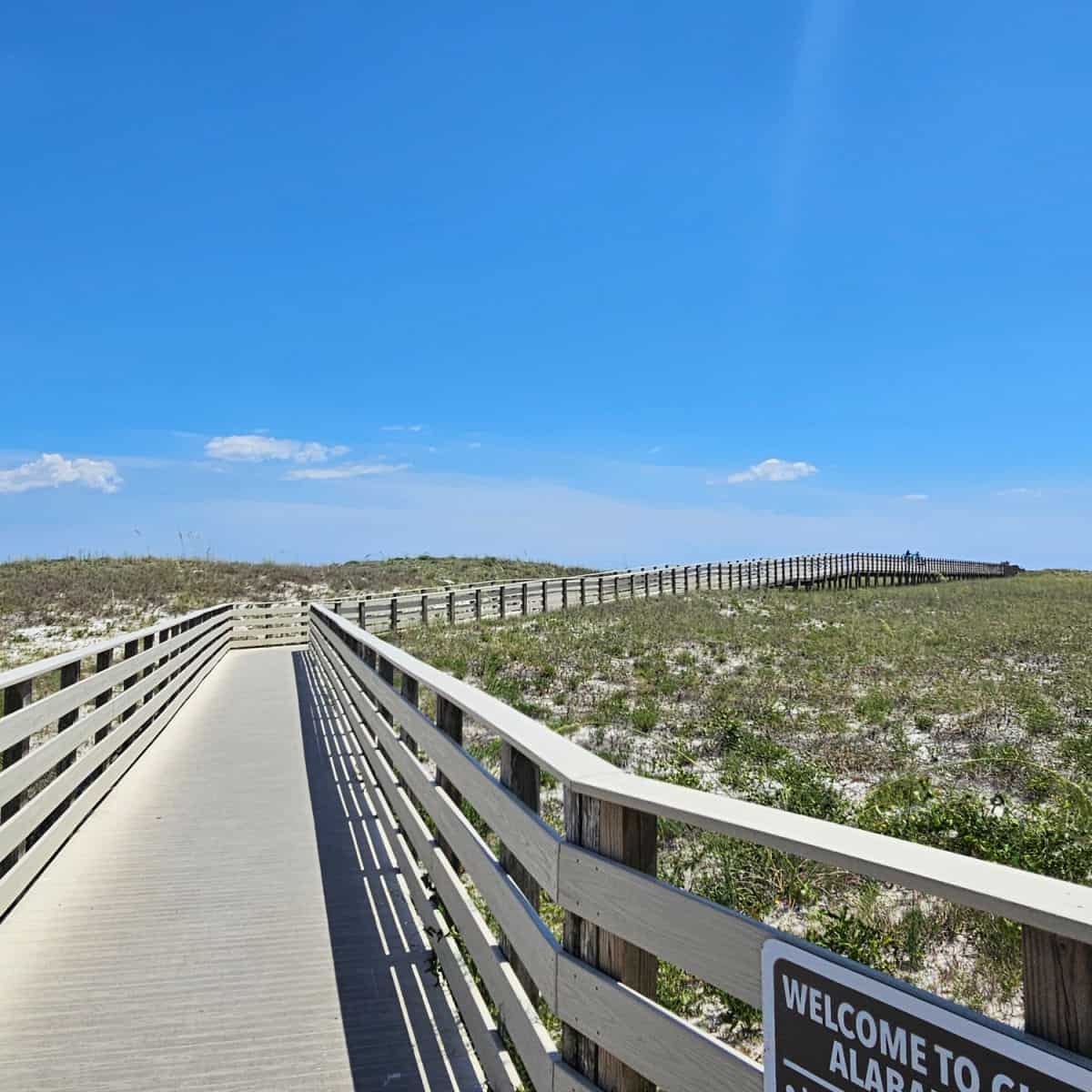 boardwalk over the sand dunes with people in the distance